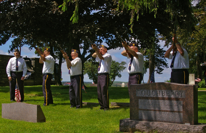 The Post Honor Guard fires a salute to honor the fallen. 